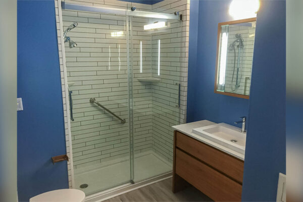 Acrylic shower mimicking subway tile with black grout after tub to shower remodeling.