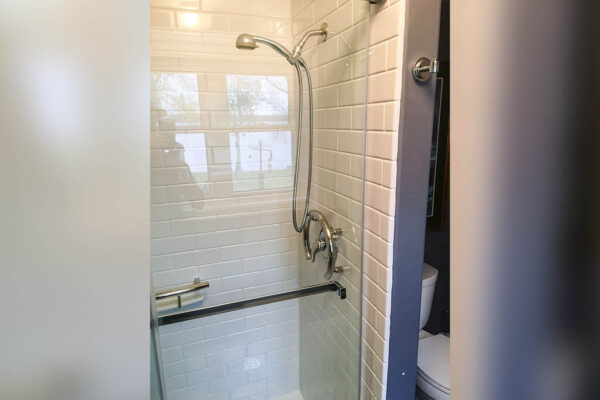 After image of a new acrylic shower with subway tile design and glass doors, highlighting bathroom remodeling and shower installation.